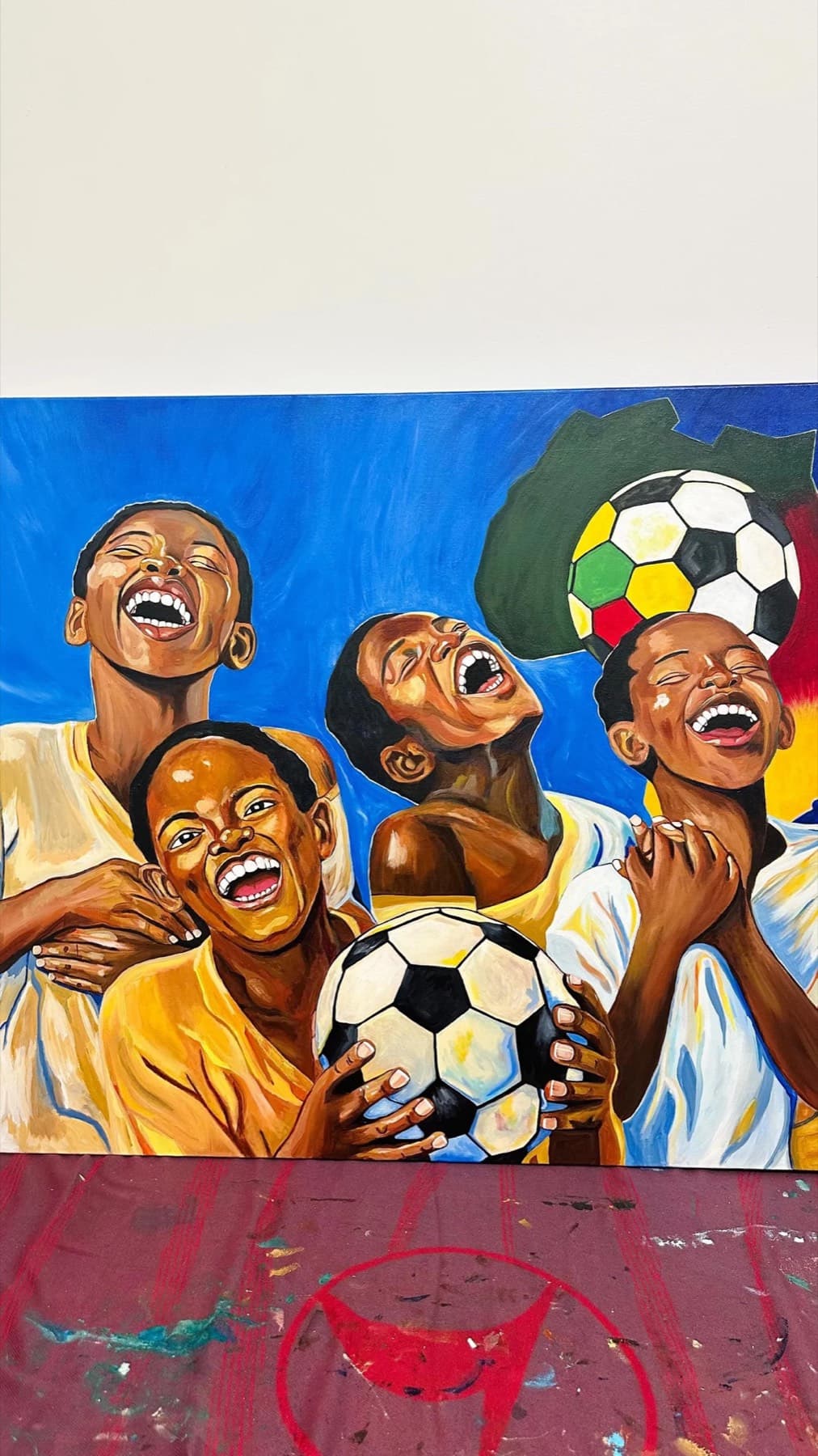 Children laughing together around a soccer ball, painted in bold blues, yellows, and browns