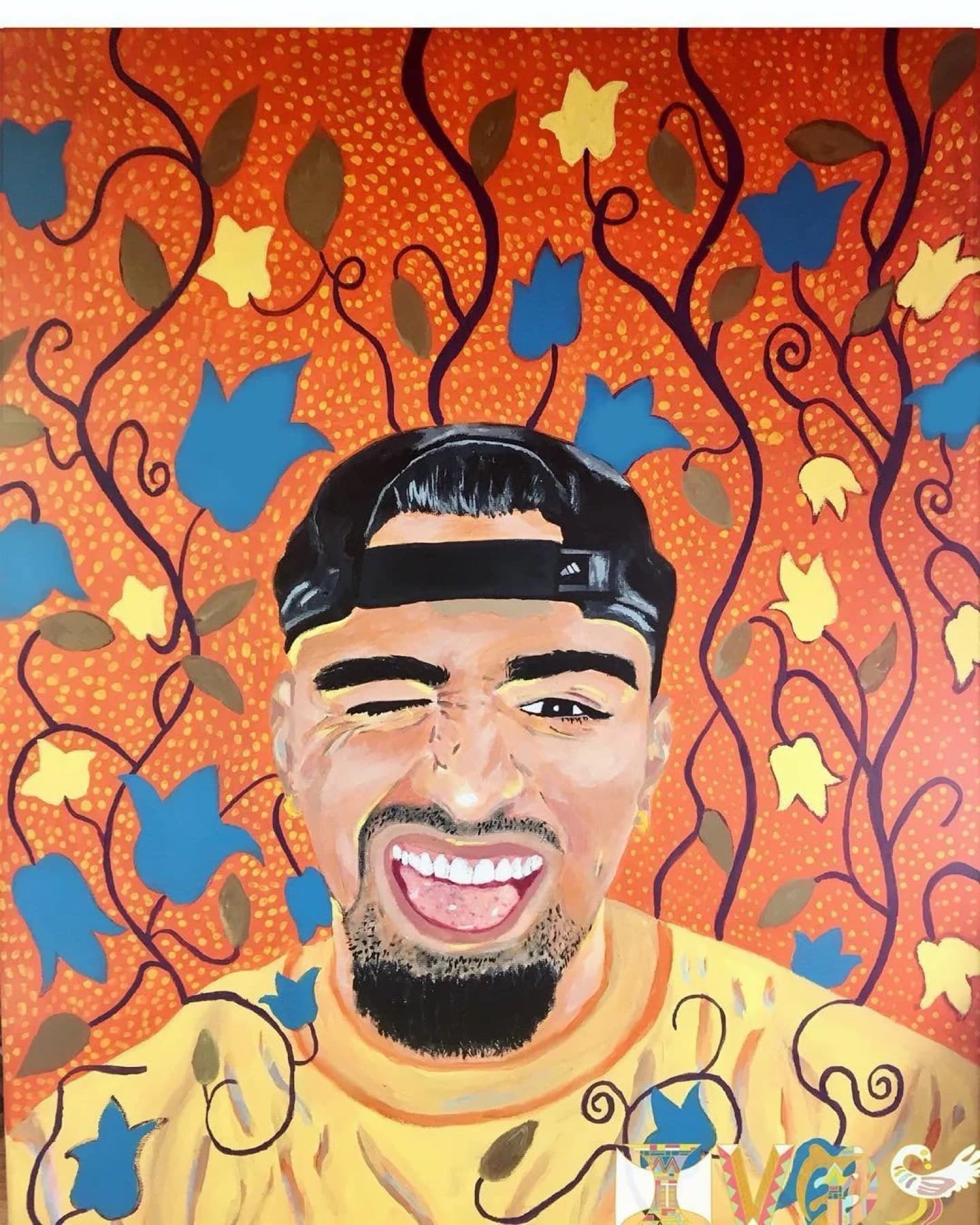 A smiling young man in a backwards cap on an orange patterned ground